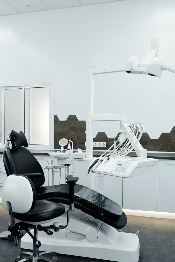 services-03 Contemporary dental clinic interior featuring advanced dental chair and equipment.